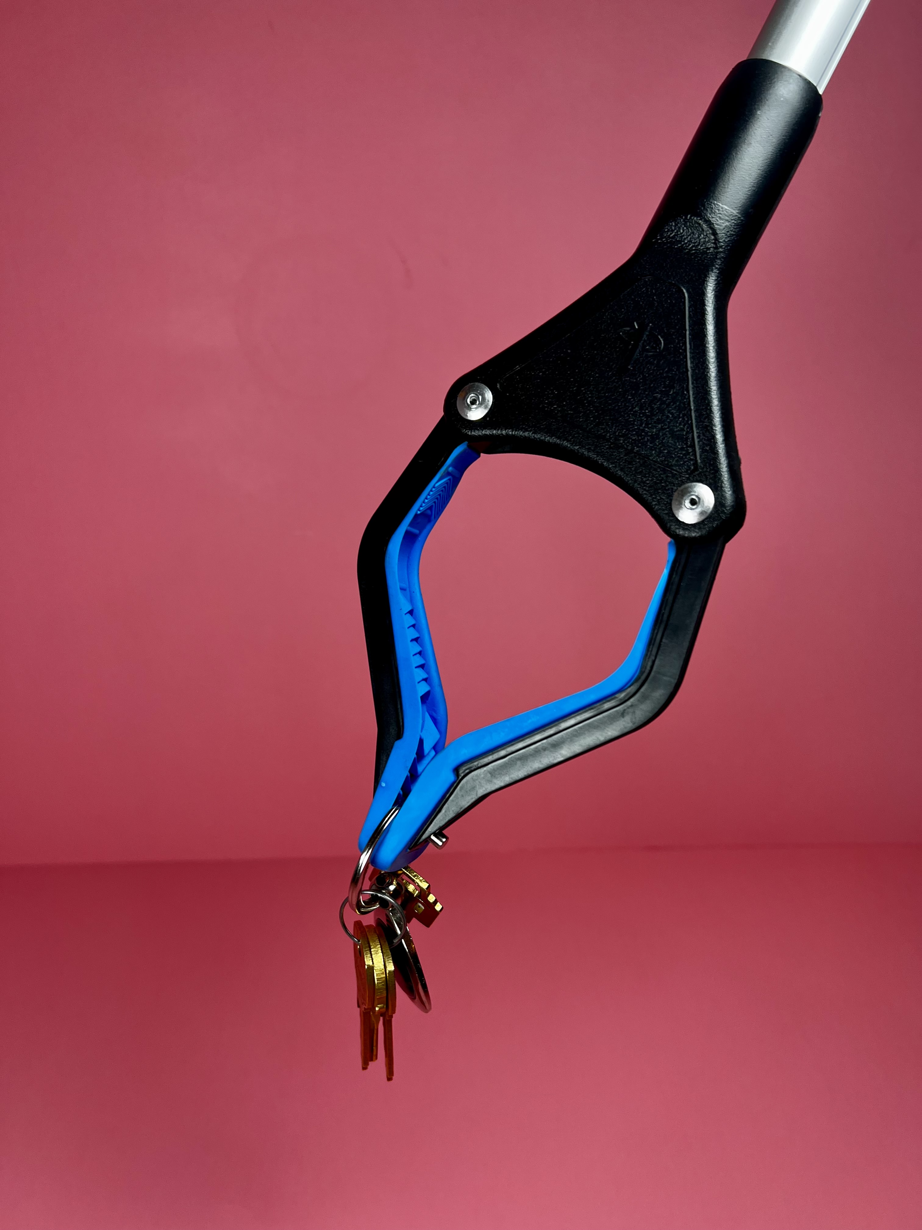 Extended grabber tool holding a set of keys.