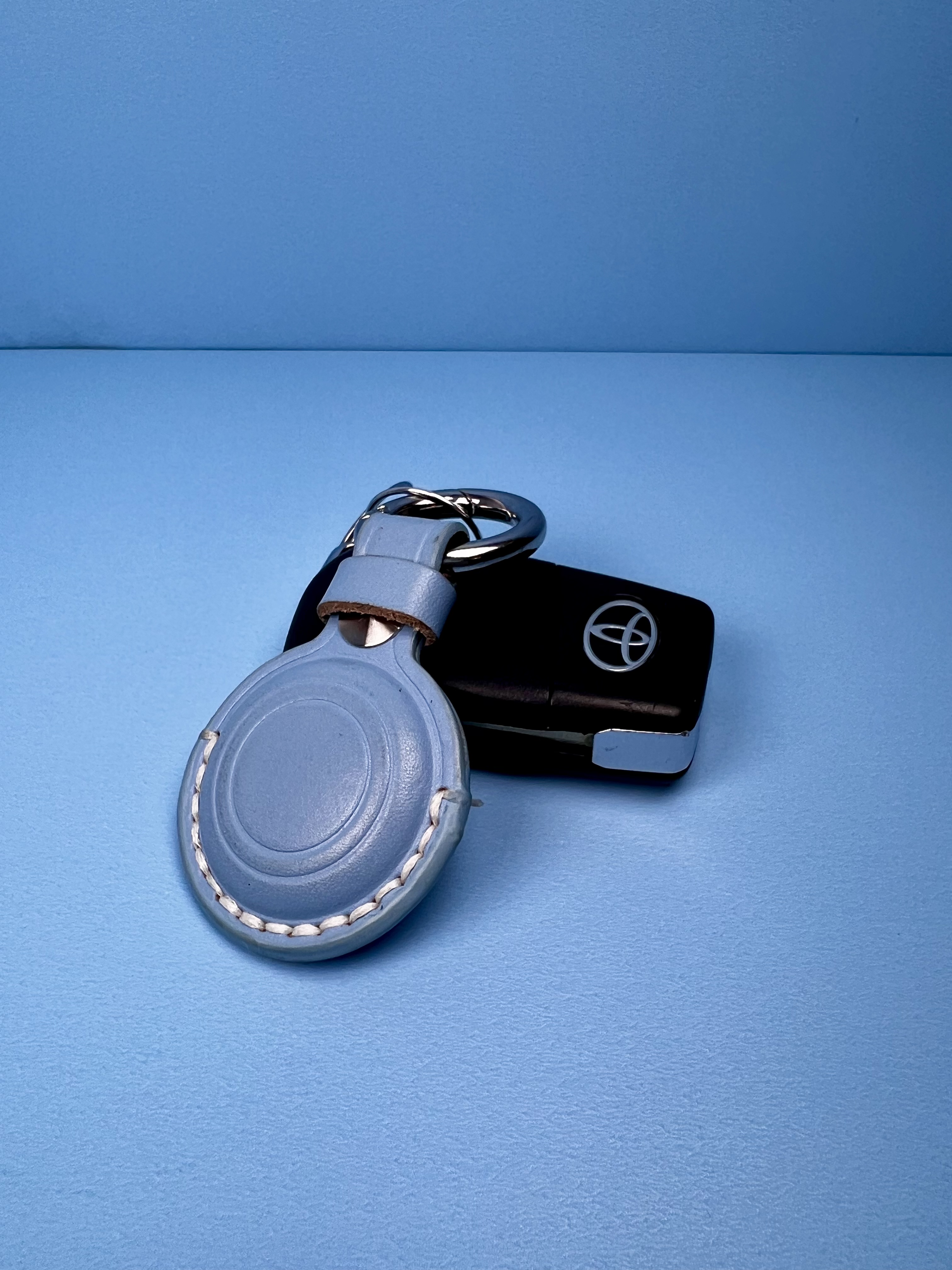 AirTag in a keychain holder attached to a set of car keys.