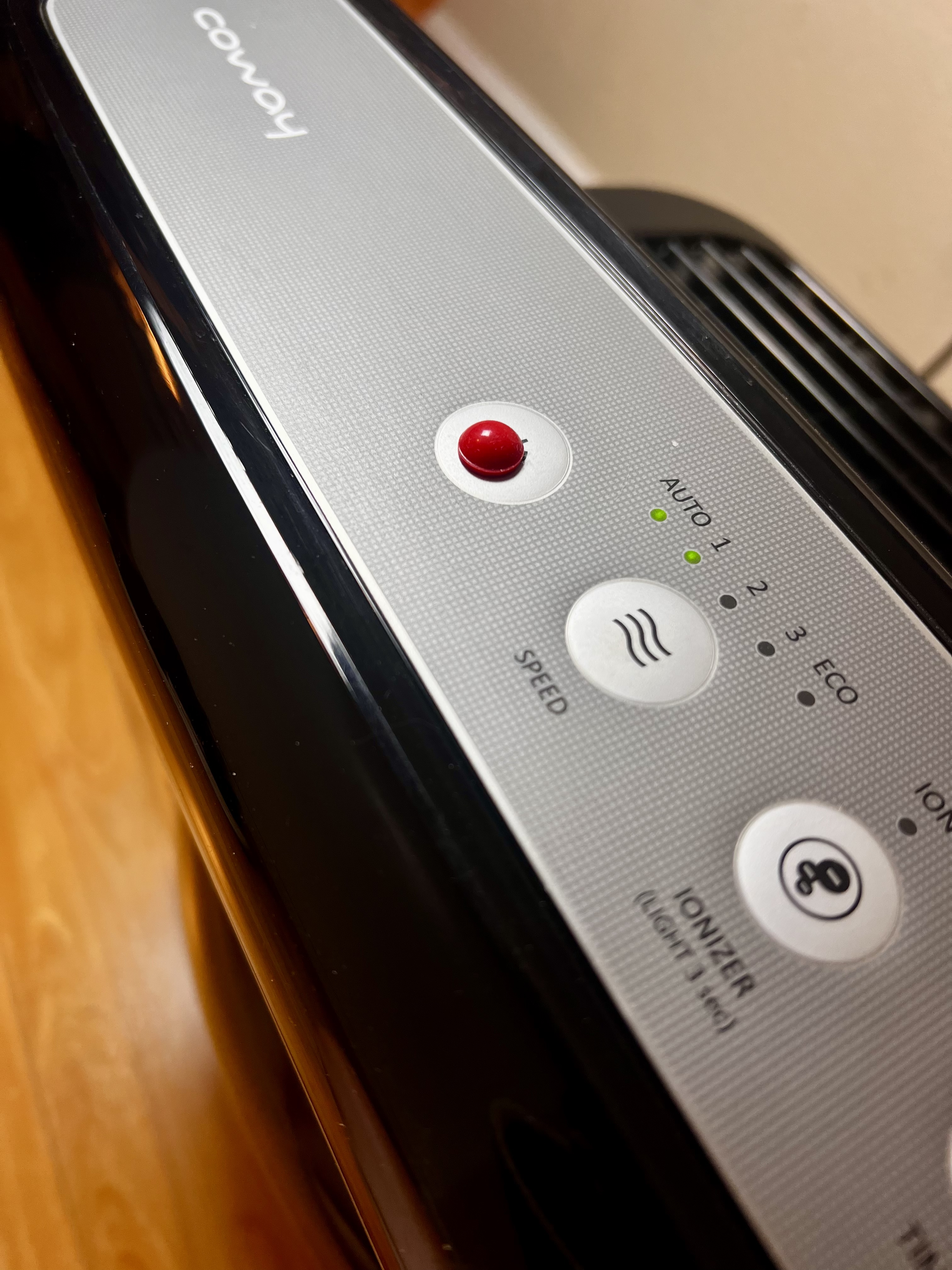 Close-up of an appliance control panel with a red tactile marker placed on a button above the speed controls.
