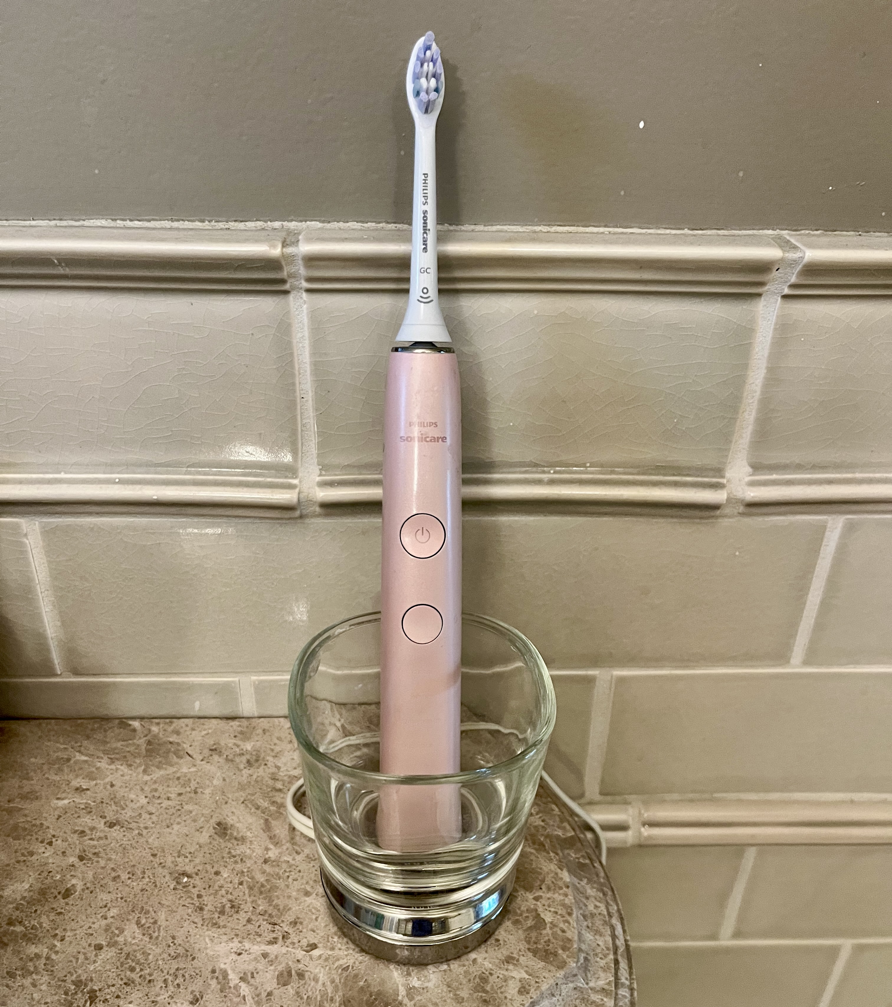 Sonicare toothbrush in charger that looks like a cup.