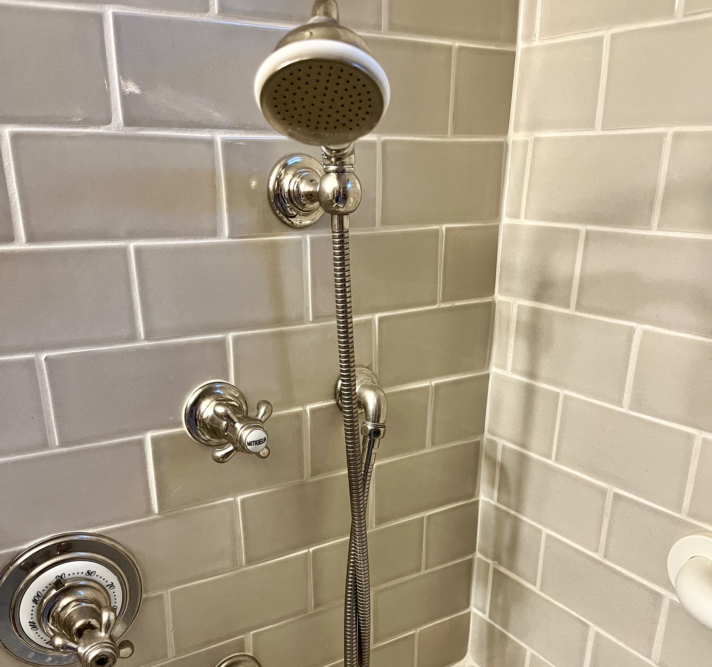Wall-mounted handheld showerhead with a flexible hose for easier washing while seated or standing.