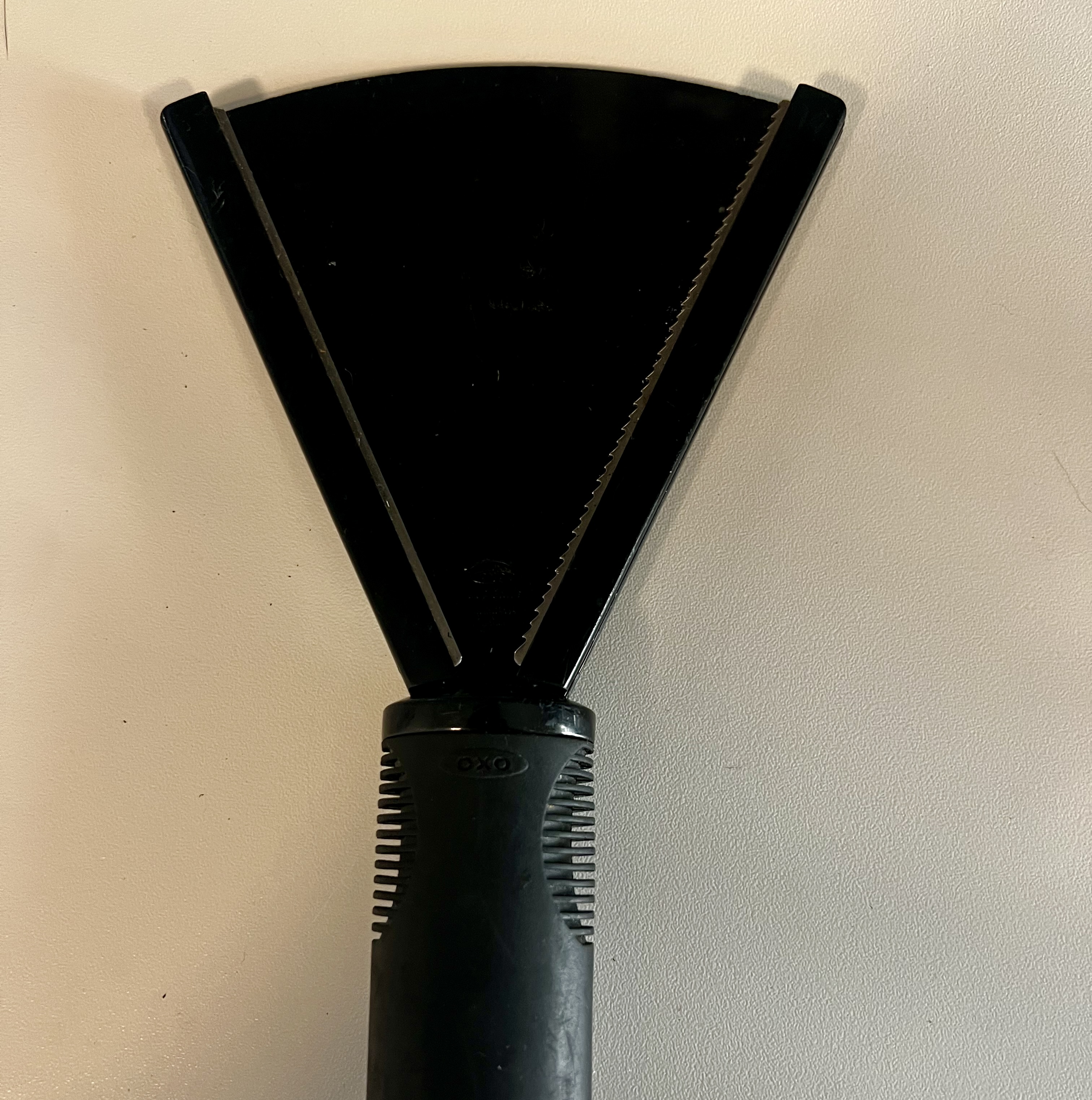 Black OXO Good Grips jar opener with a wide V-shaped gripping head and textured handle.