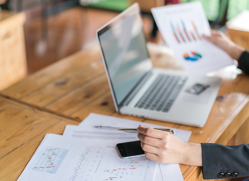 Laptop and printed charts on a desk — product data audit