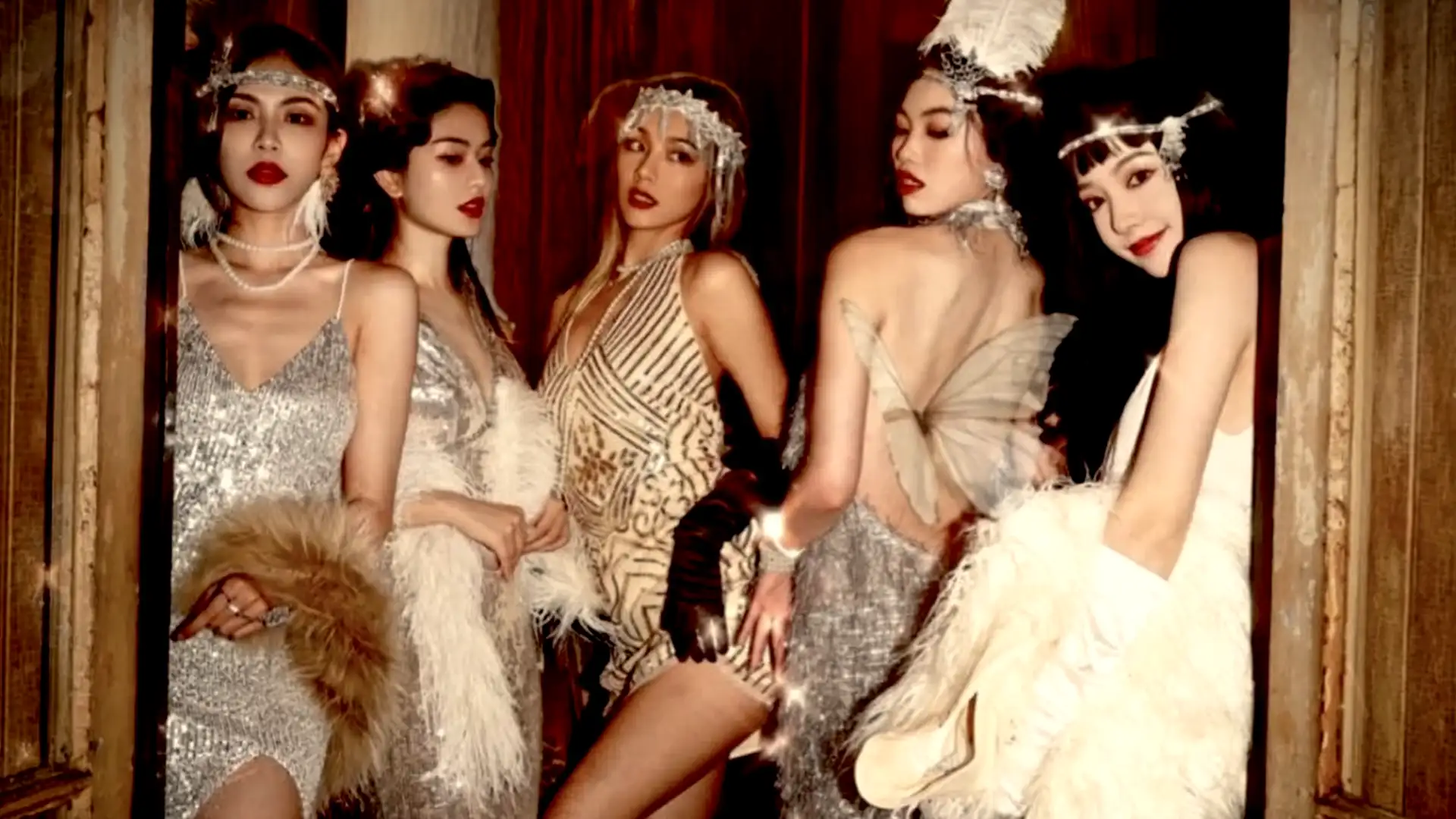Performers in silver flapper dresses and feather headpieces at a party