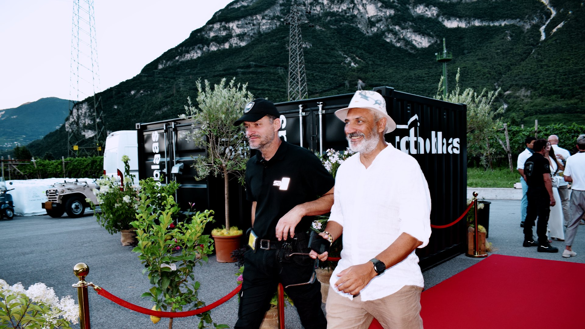 Guests walking onto the red carpet at dusk at a company event