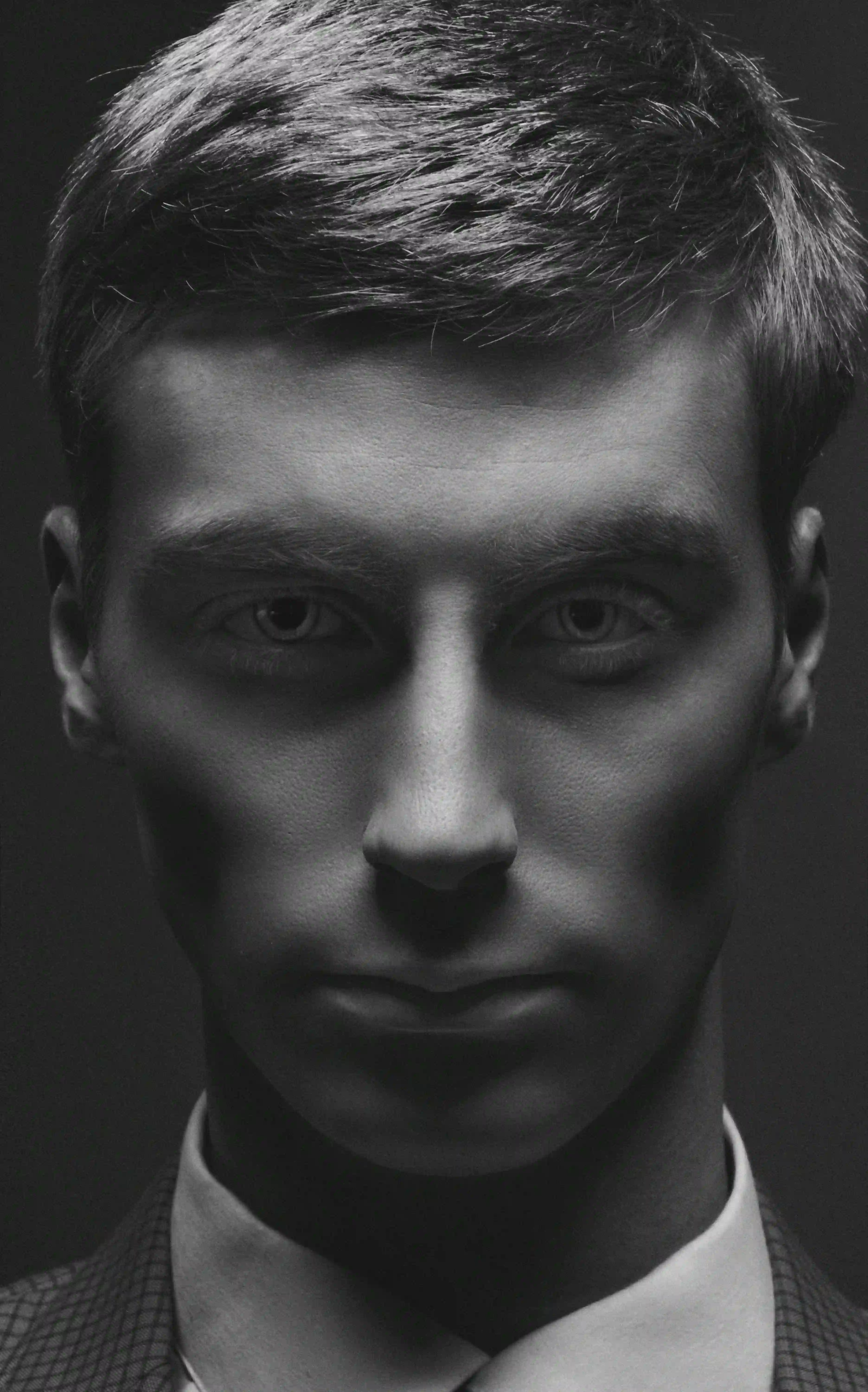 Black and white formal portrait of male model in suit jacket and turtleneck, part of the Cover Page Dubai model roster