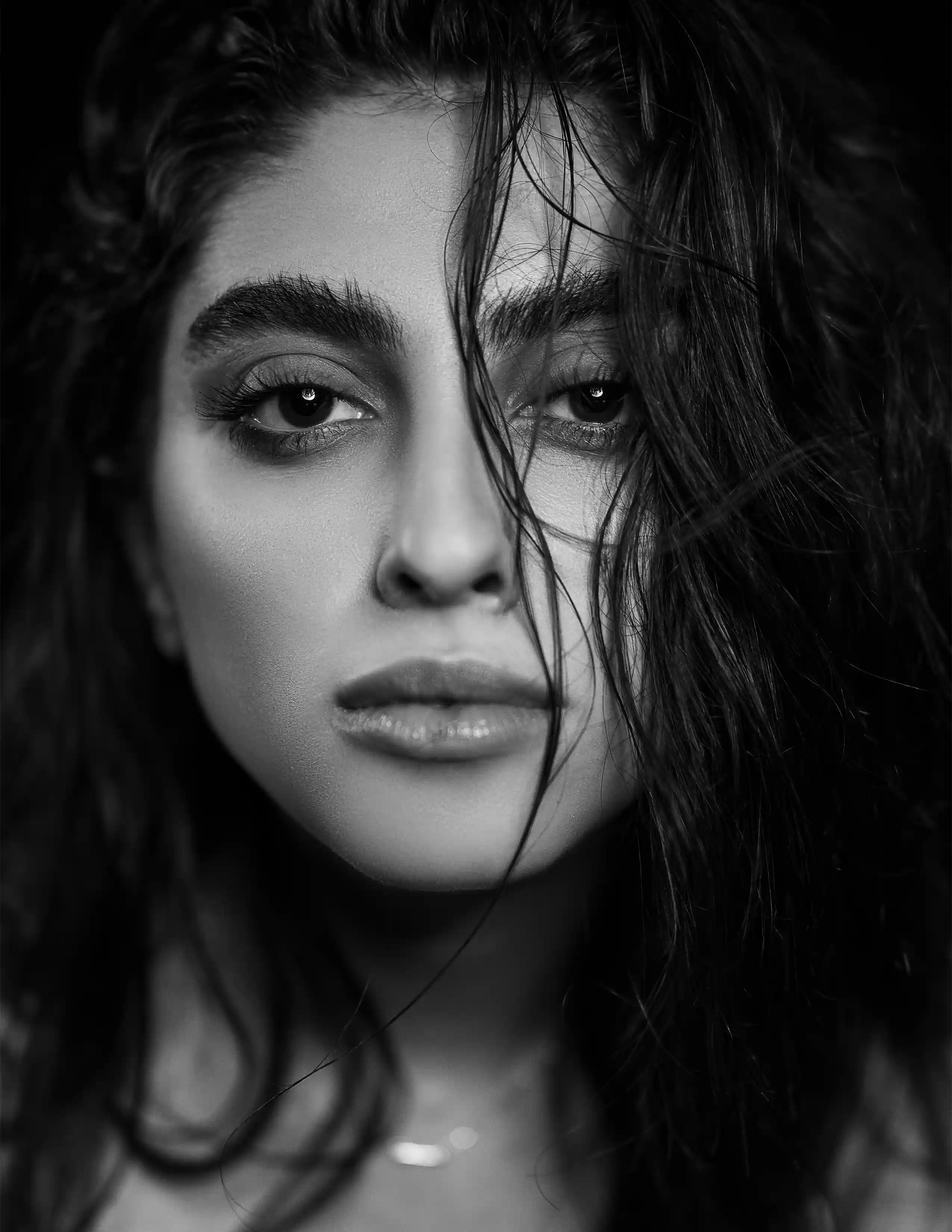 Close-up black and white portrait of female model with dark hair and glossy lips, part of the Cover Page Dubai model roster
