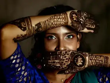 Henna artist decorating a hand
