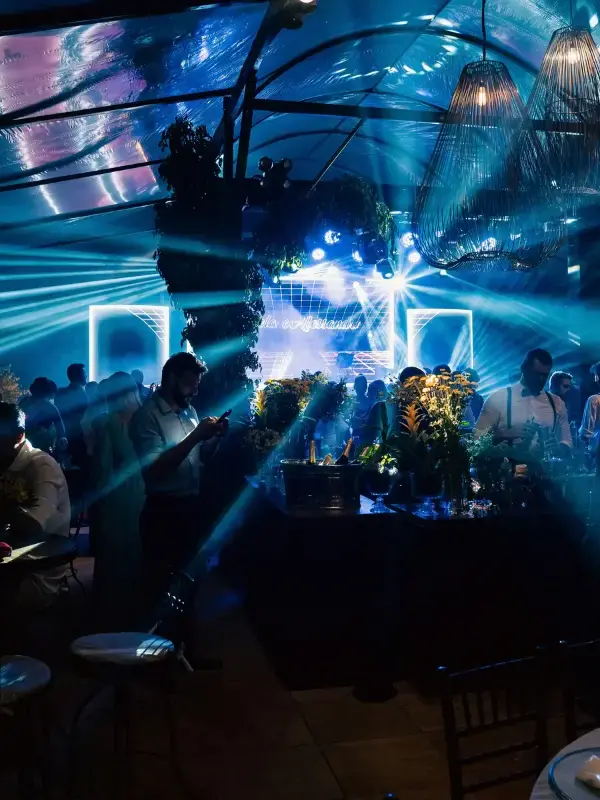 Guests at an evening event in front of a stage under blue light