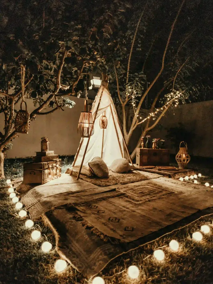 Small lit tent set in a garden for an evening event