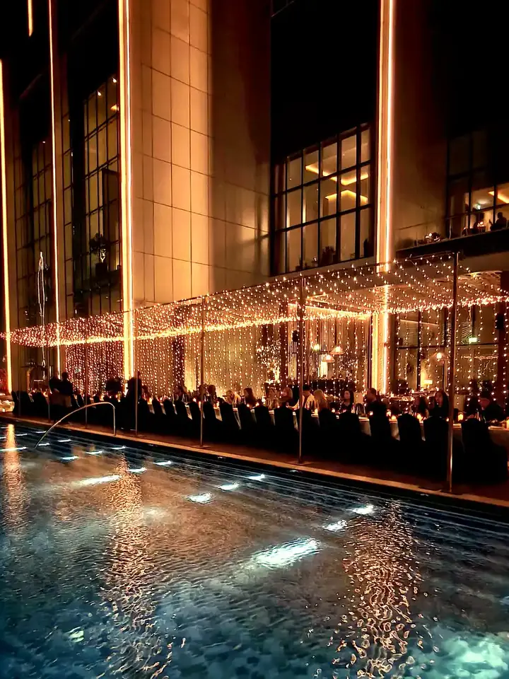 Event structure lit with fairy lights by a pool