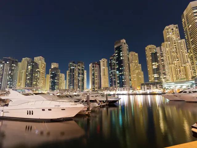 Motor boat moored in Dubai Marina at night under the towers