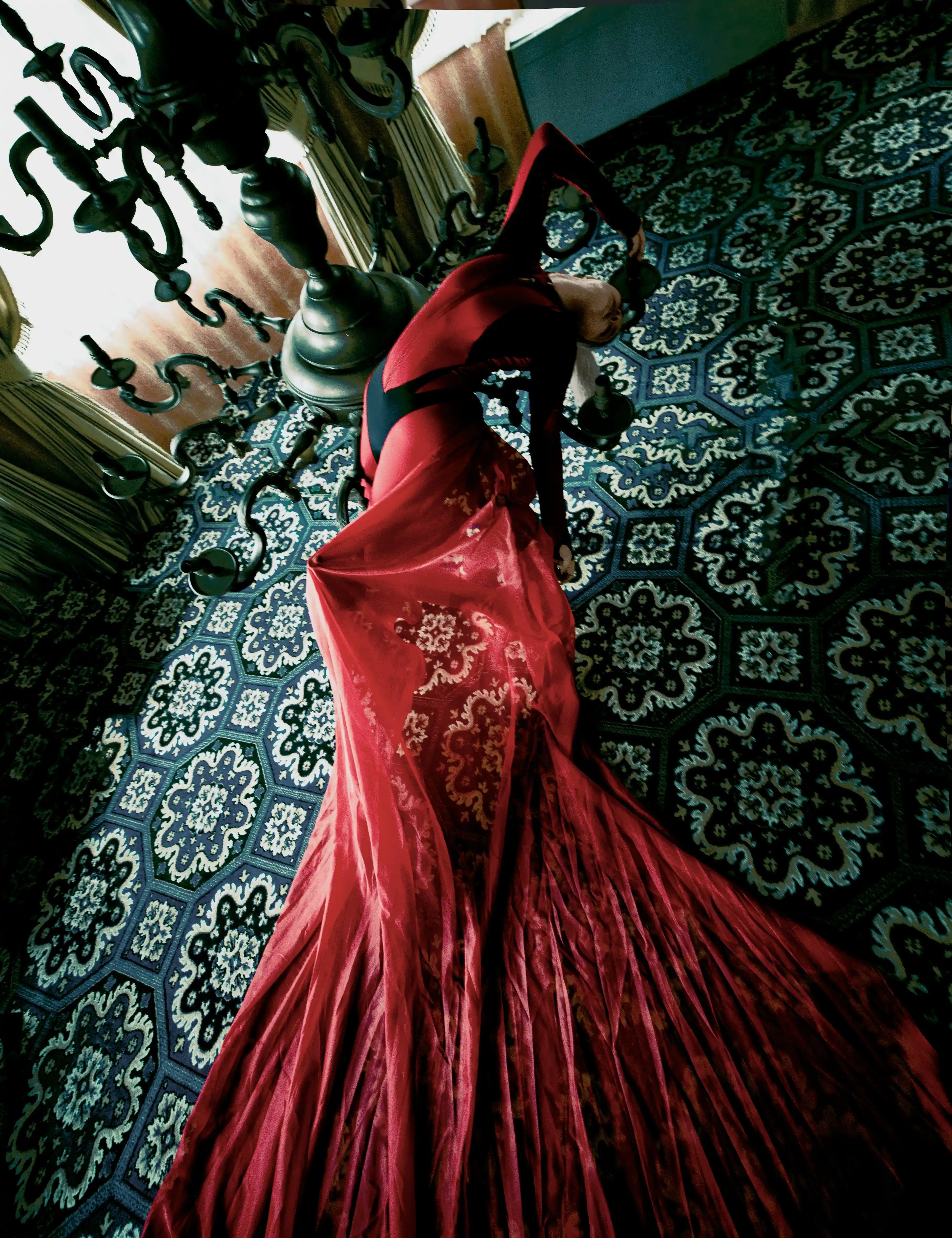 Dynamic performer in red gown bending in dramatic pose for luxury event in Dubai by Coverpage.