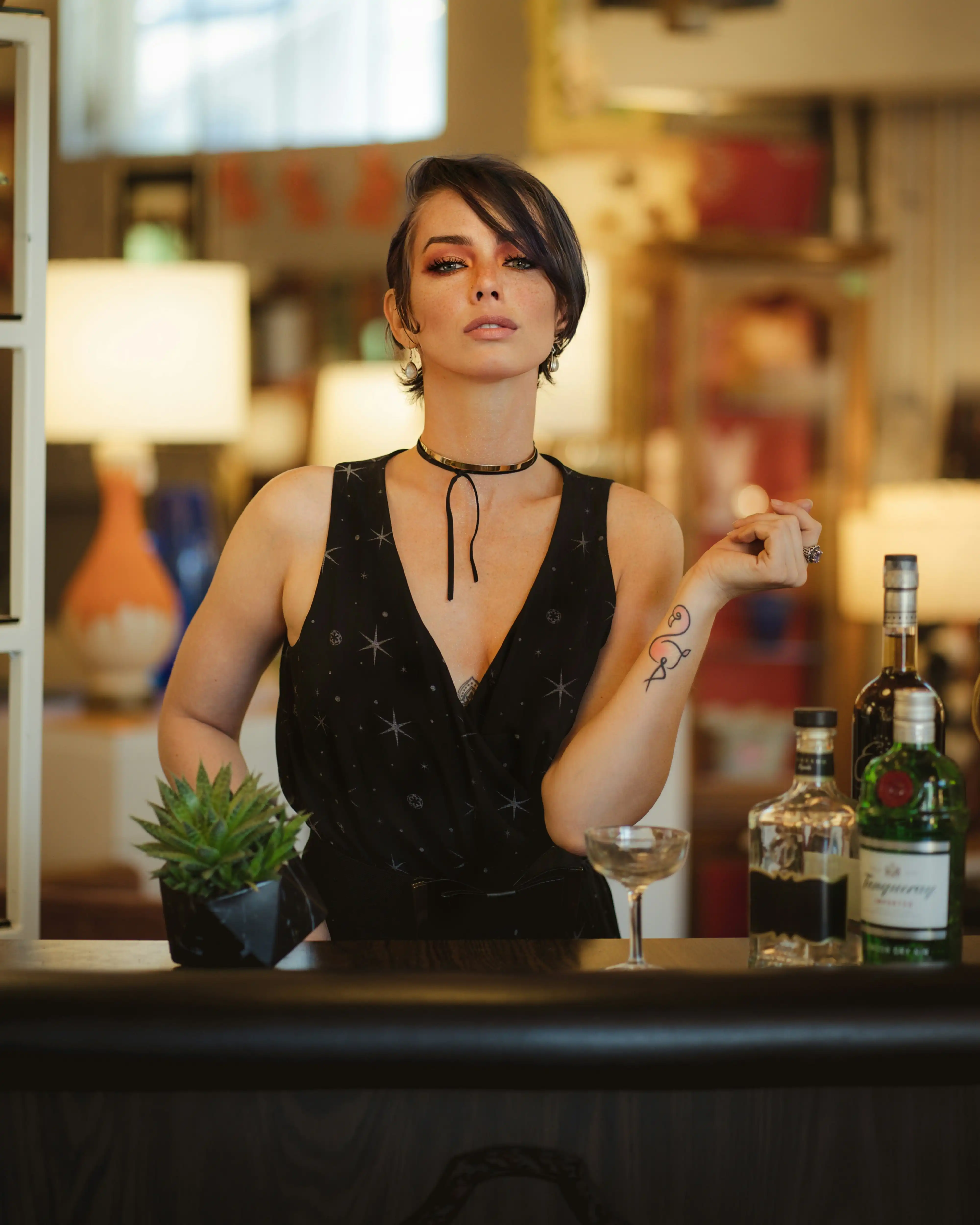 Starry top bartender talent posing at cocktail bar with gin and tequila for Coverpage Dubai luxury event agency.