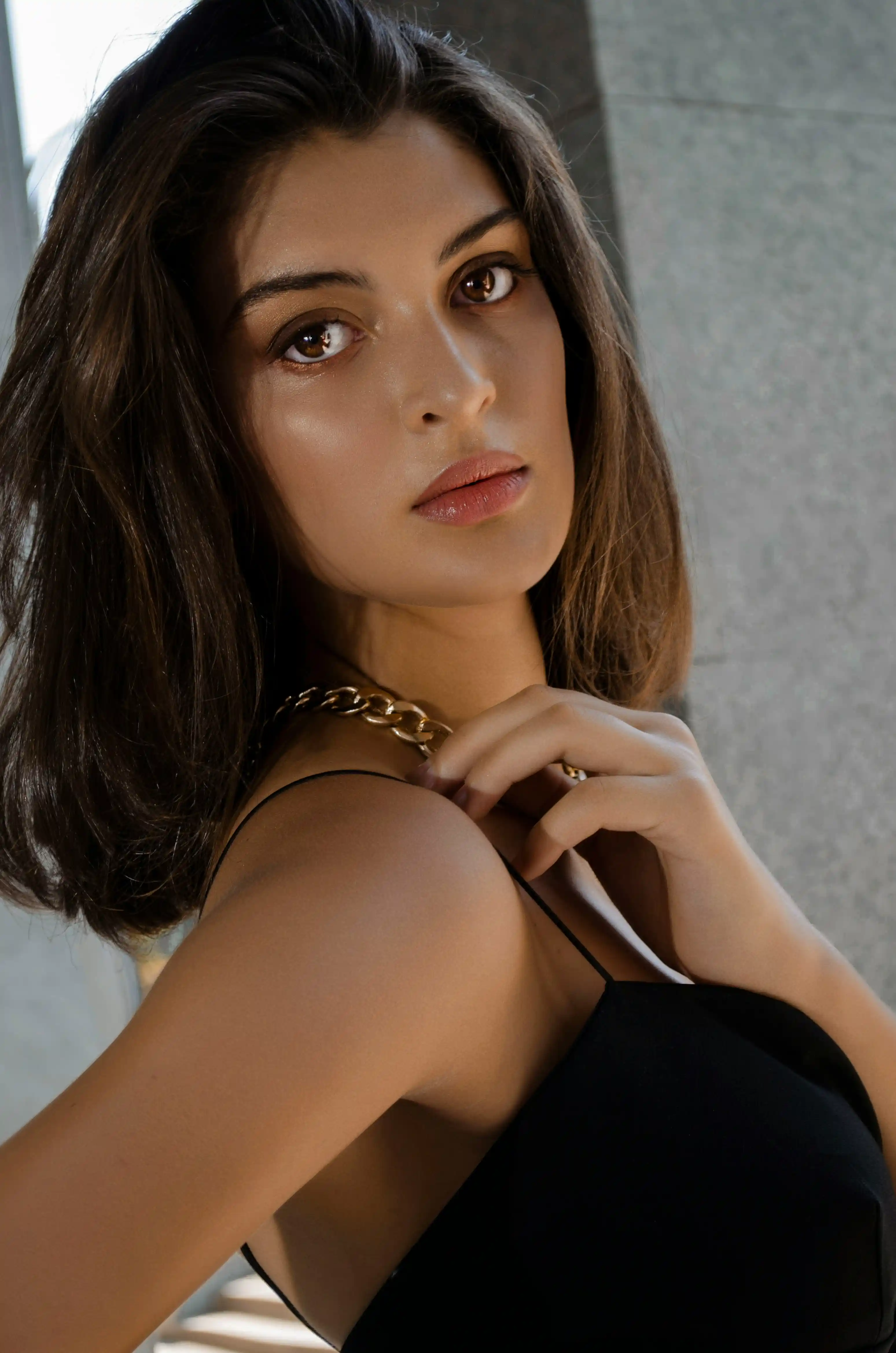 Elegant model talent in black strapless dress posing with hand on shoulder for Coverpage Dubai fashion agency.