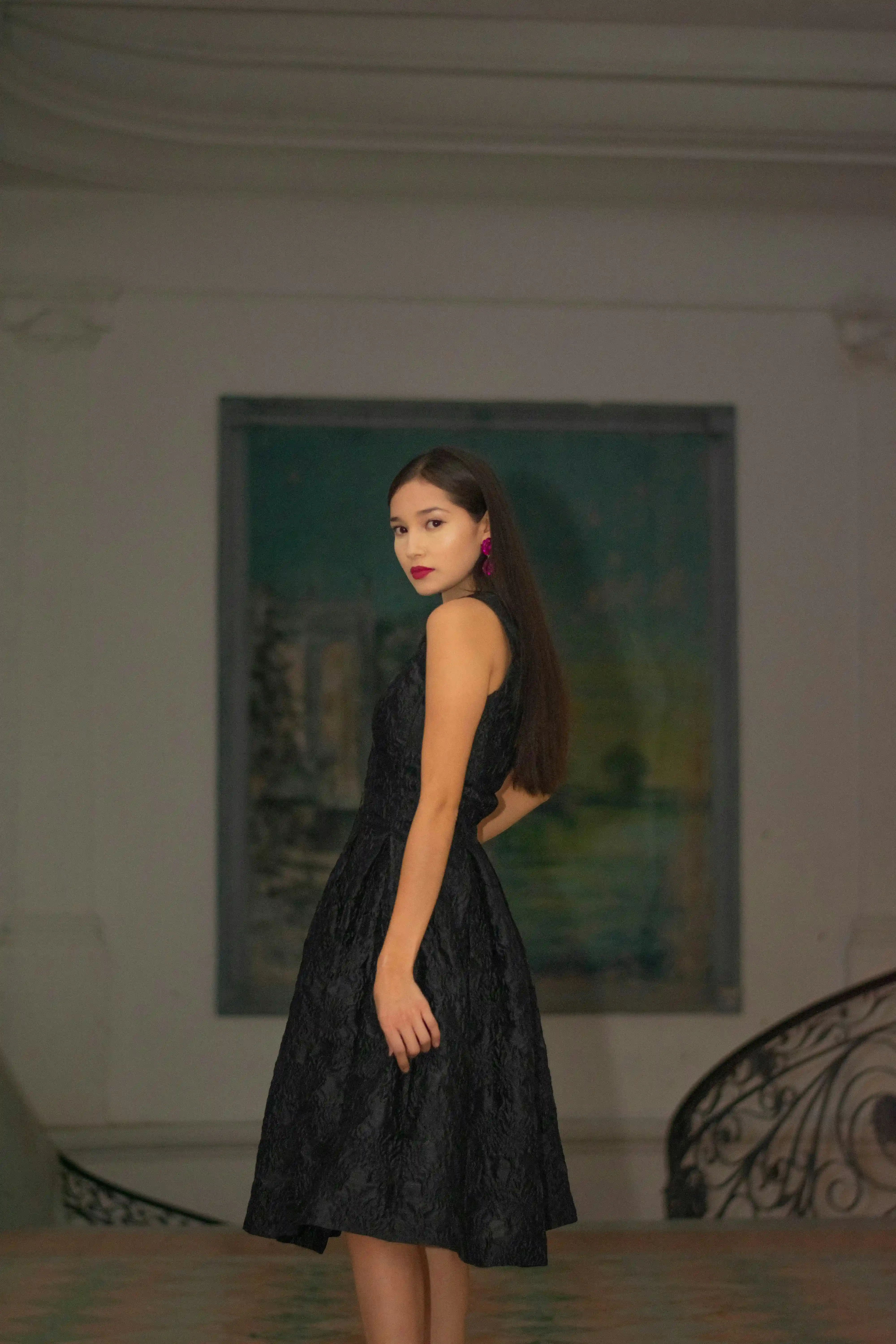 Sophisticated model talent in textured black dress standing in elegant hall for Coverpage Dubai luxury showcase.