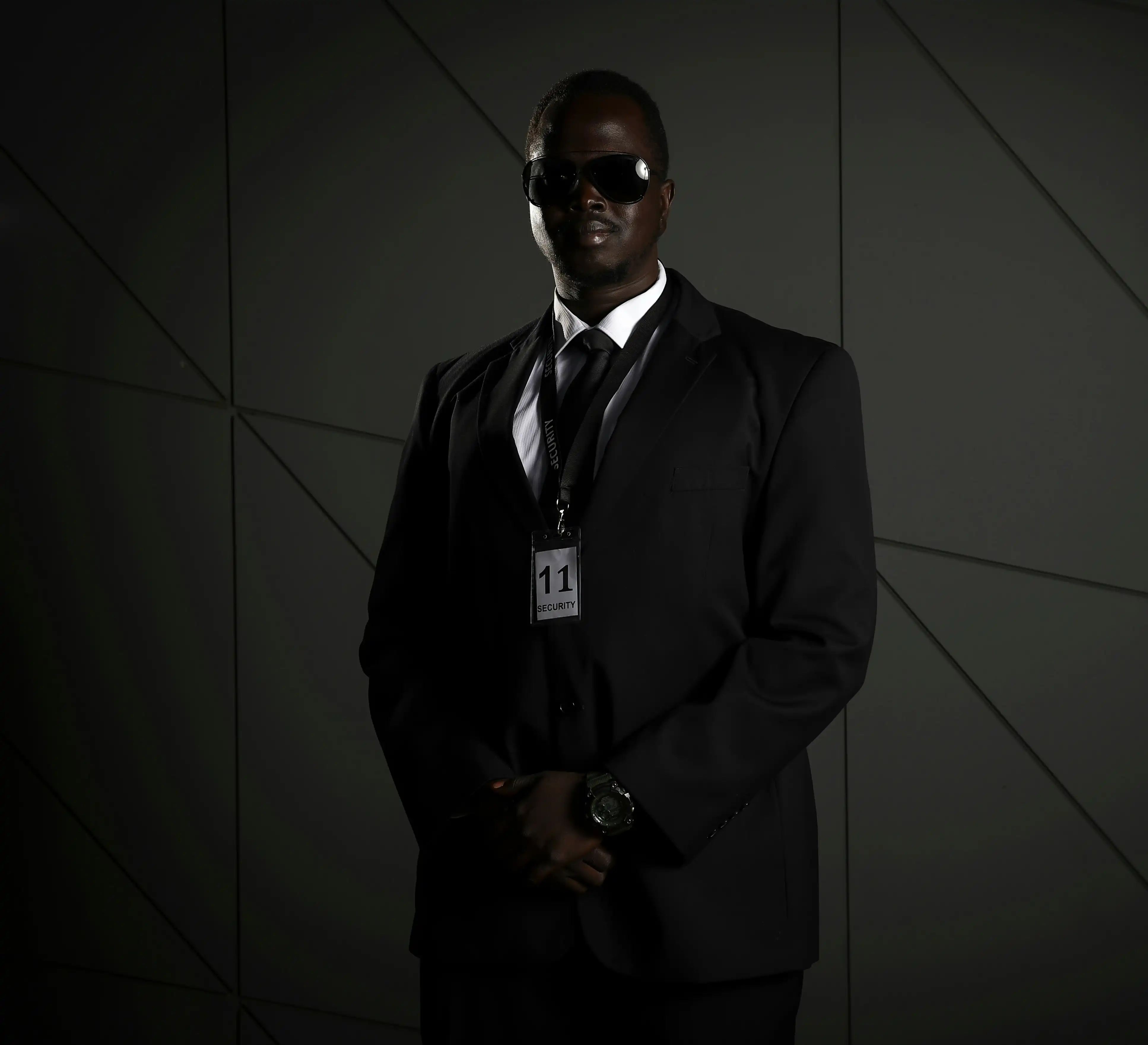 Professional security talent in black suit with sunglasses and ID badge for Coverpage Dubai entertainment agency.