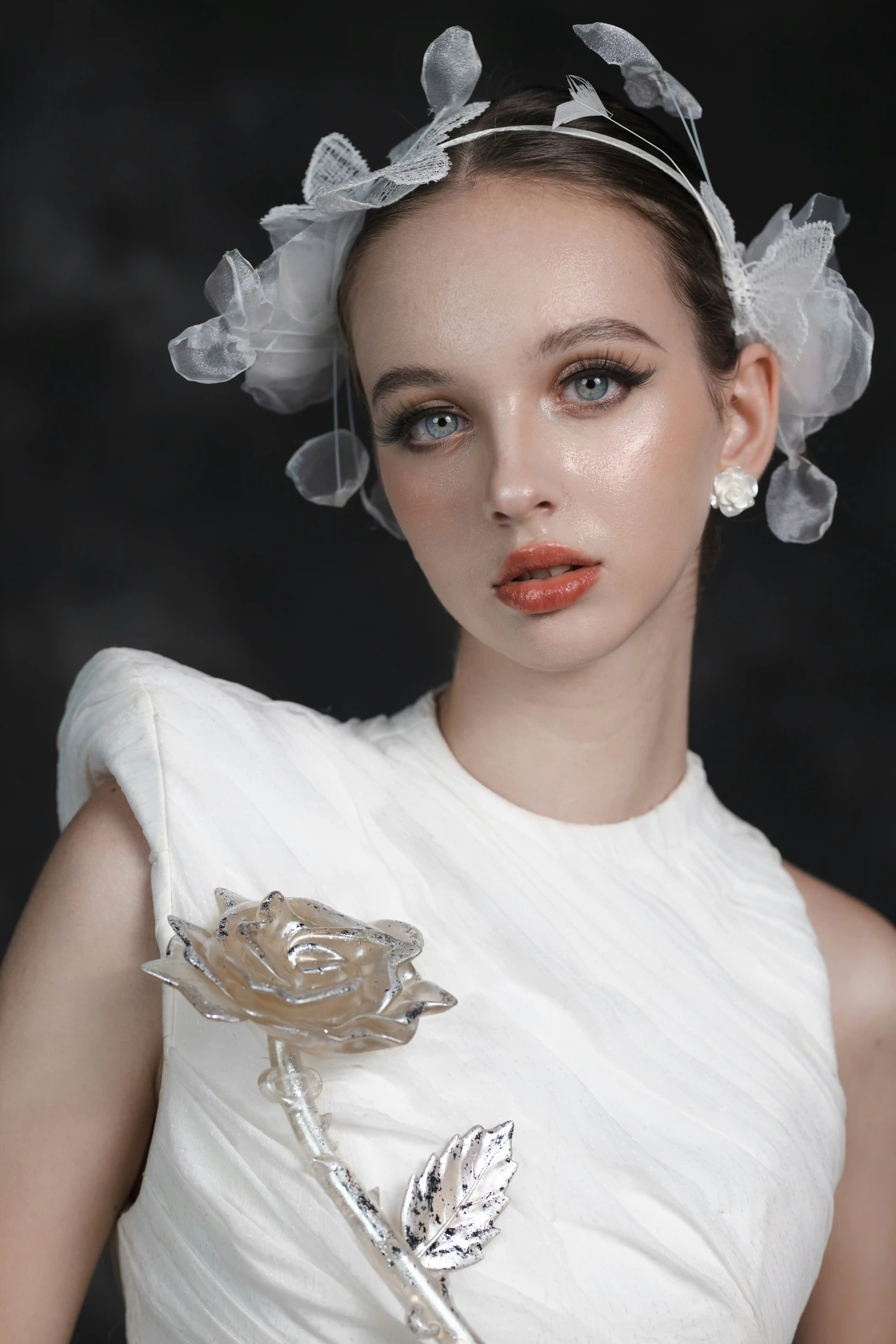 Cover Page model in patterned headscarf and lace floral mermaid gown, posing gracefully in architectural hallway with potted plants.