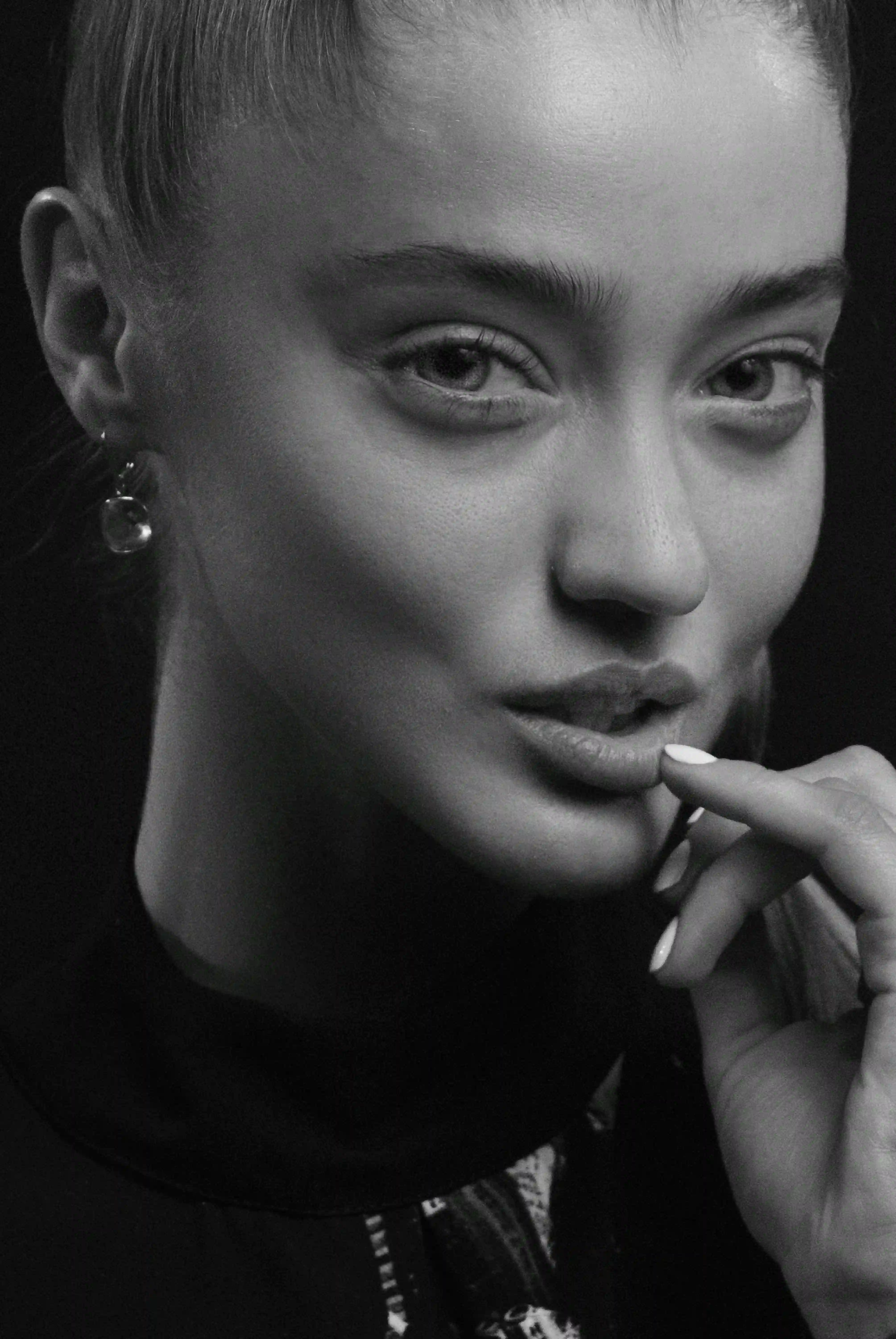 Glamorous black and white fashion portrait of woman with dark bold lipstick, large statement diamond earrings, head tilted back, seductive gaze and glossy lips, luxury high-end beauty shot