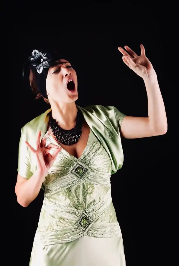 Elegant luxury opera singer in a stunning sage green satin gown passionately performing with dramatic expression for Cover Page Agency Dubai. High-end classical entertainment talent delivering powerful, sophisticated performances at exclusive events and luxury soirées across the UAE.