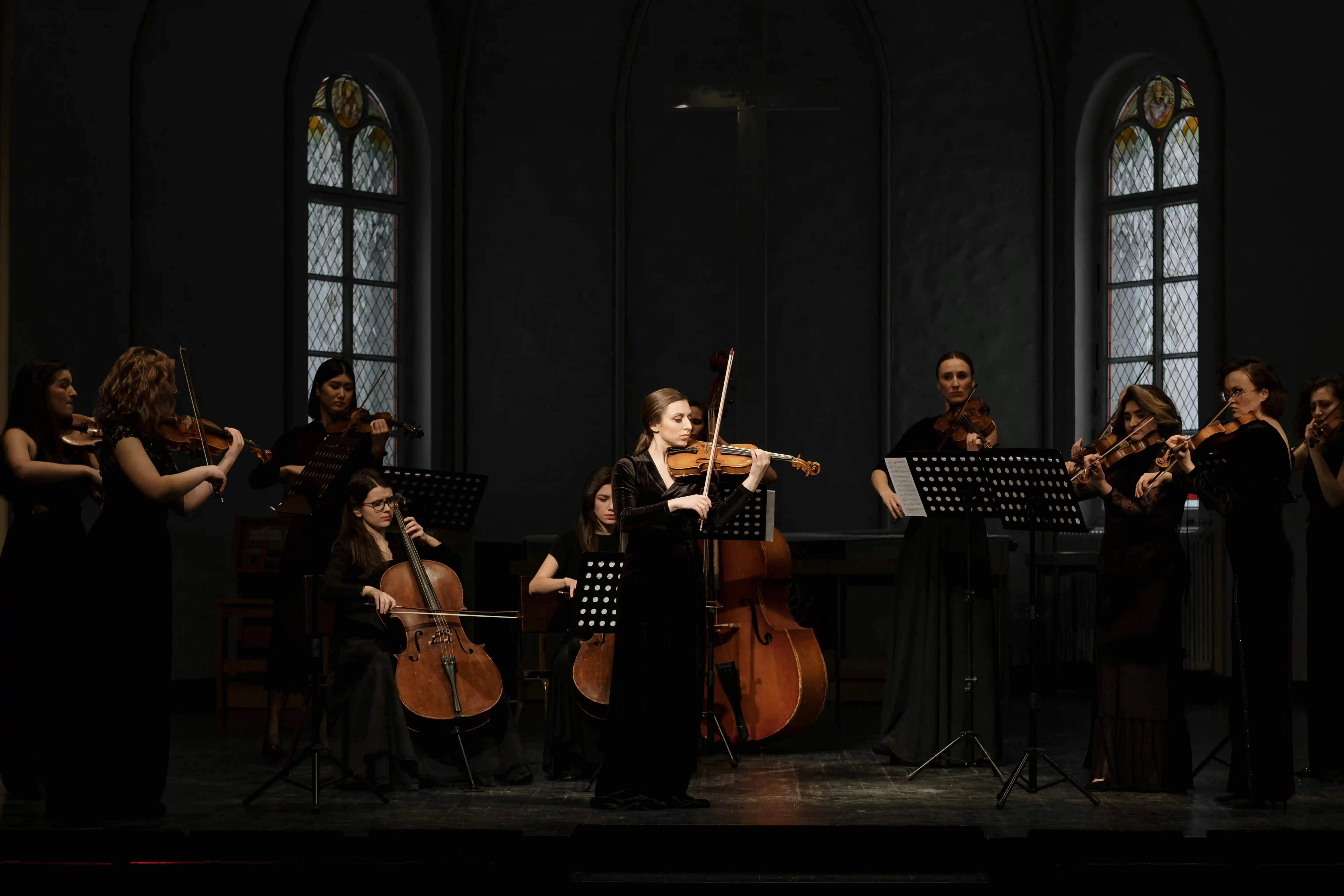 Elegant luxury string orchestra in sophisticated black attire passionately performing violins and cello for Cover Page Agency Dubai. High-end classical music ensemble delivering refined, world-class live performances at exclusive events, galas and luxury soirées across the UAE.