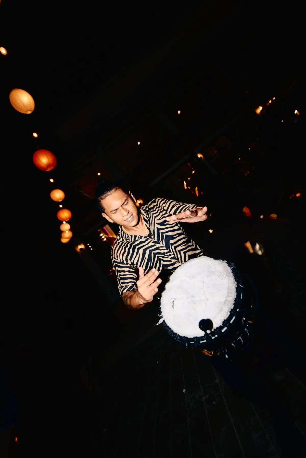 Dynamic luxury percussionist passionately playing a traditional drum with high energy and expressive performance for Cover Page Agency Dubai. High-end rhythmic entertainment talent delivering captivating live percussion shows at exclusive events and luxury parties across the UAE.
