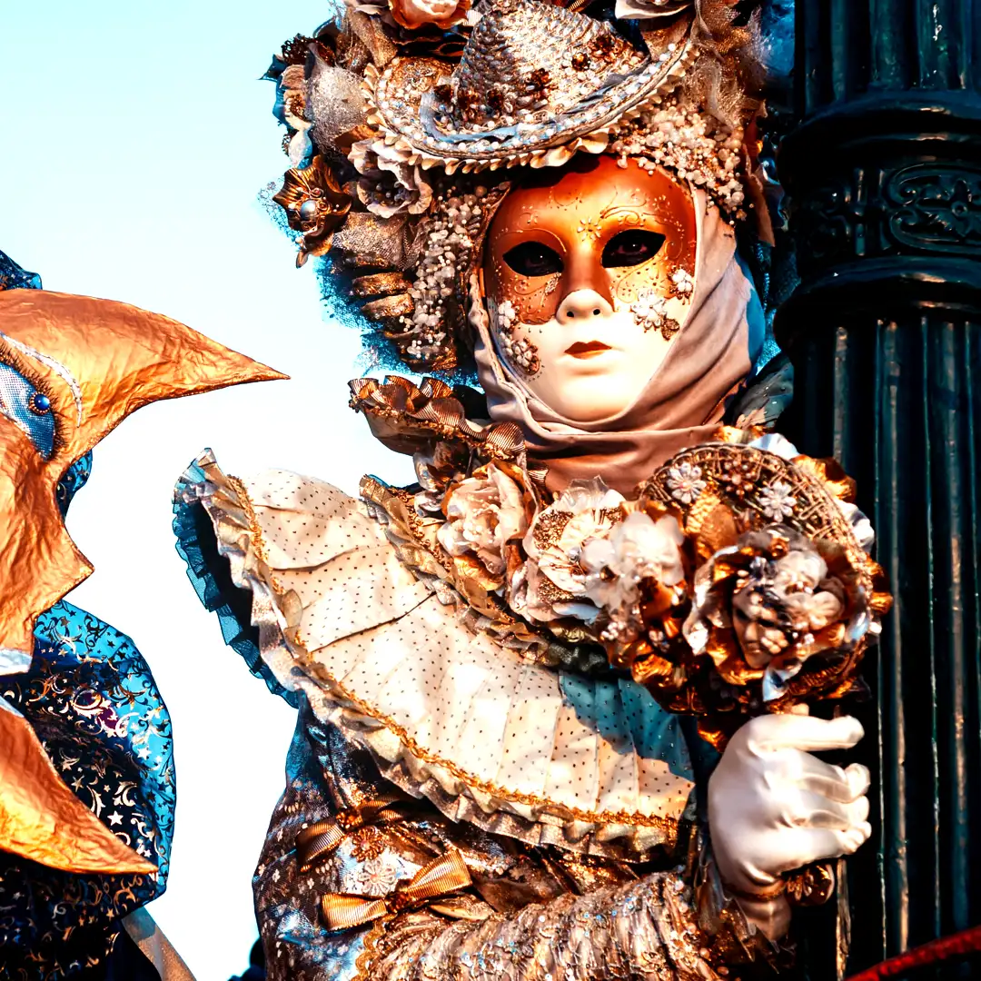 Stunning luxury Venetian carnival performers in ornate gold and blue masks with elaborate costumes and headdresses for Cover Page Agency Dubai. High-end theatrical entertainment talent delivering glamorous, mysterious and visually spectacular performances at exclusive events and luxury masked balls across the UAE.