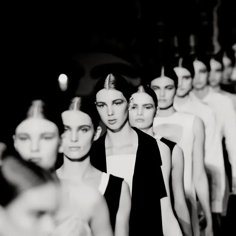 Models lined up on the runway at a fashion show, black and white