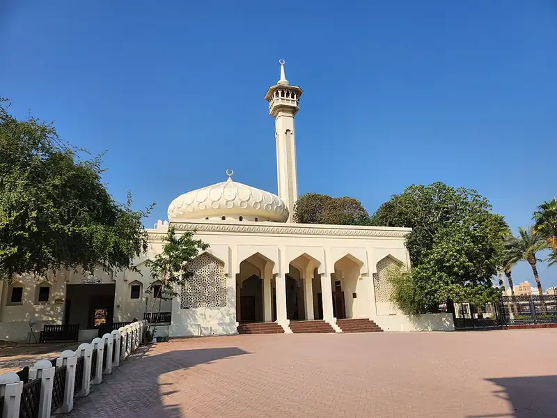 White mosque with a single minaret and an open courtyard in Dubai