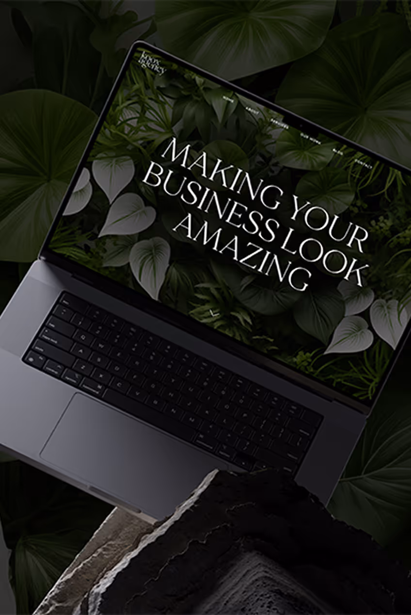 Laptop showing website with text 'Creating Construction Solutions' and orange design elements on a dark background.