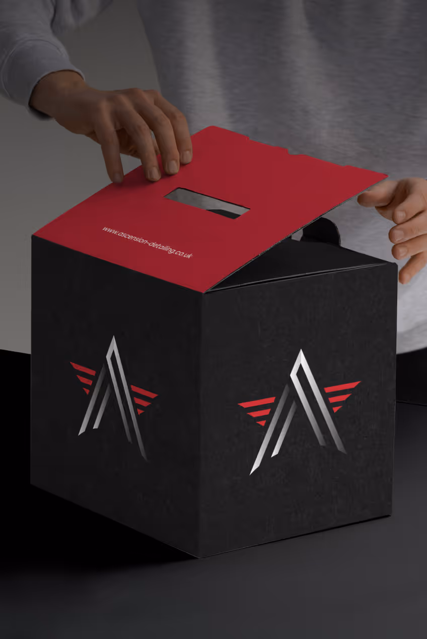 Hands opening a black and red box with a silver and red angular logo on the sides.