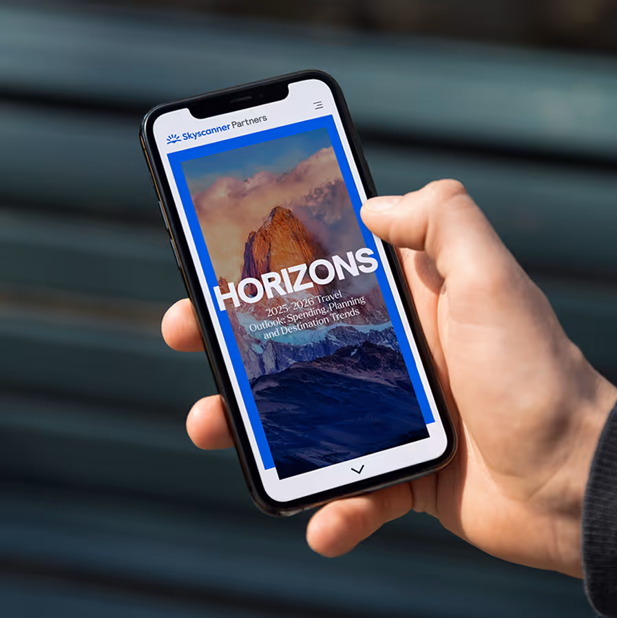 Hand holding smartphone showing Skyscanner Partners report titled Horizons with a mountain image background.