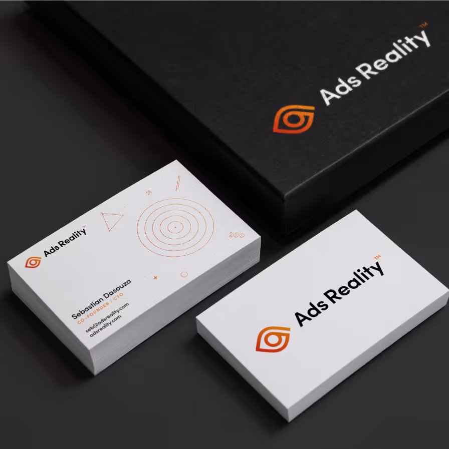 Stacks of Ads Reality business cards featuring a logo and contact info for Sebastian Dasouza.