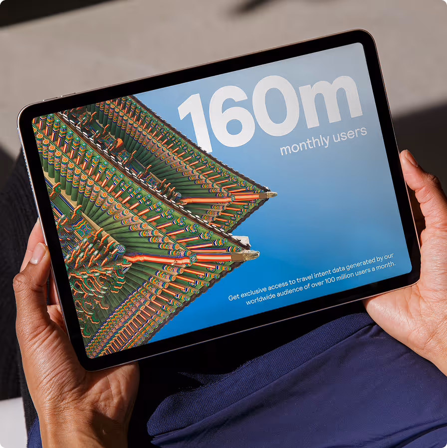 Tablet showing ornate building roof corner with text '160m monthly users' on a blue background.