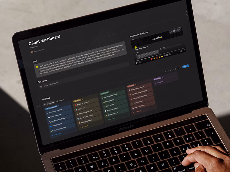 Laptop screen shows a dark-themed client dashboard with brief, notes, and multicolored action task cards.