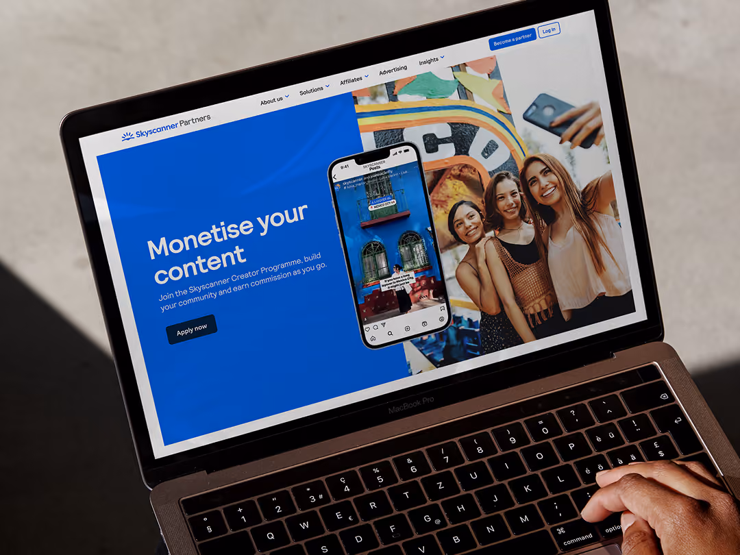Open laptop screen showing Skyscanner Partners page about monetising content with a creative community program.