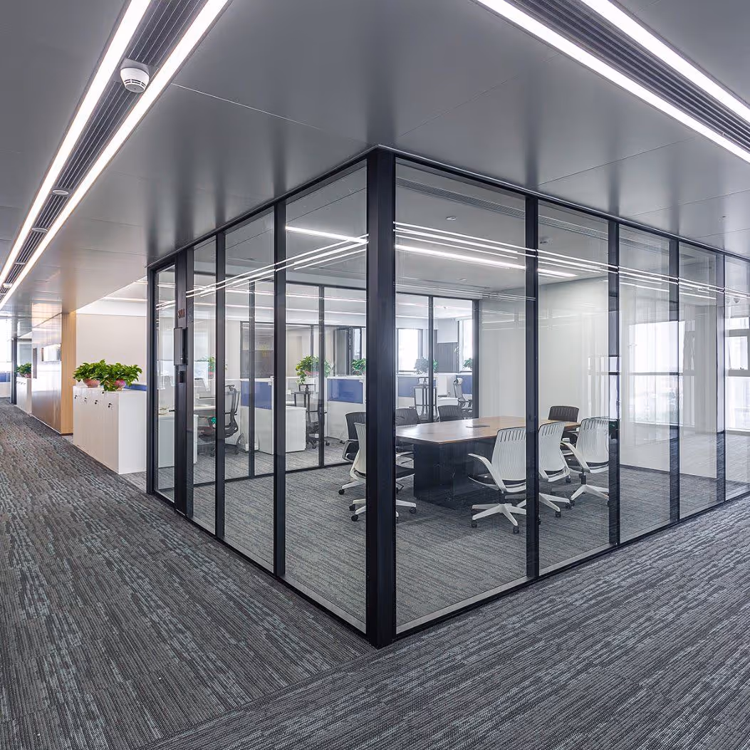 Moderne kantoorruimte met glazen wanden, vergadertafel en bureaustoelen in een open kantooromgeving.