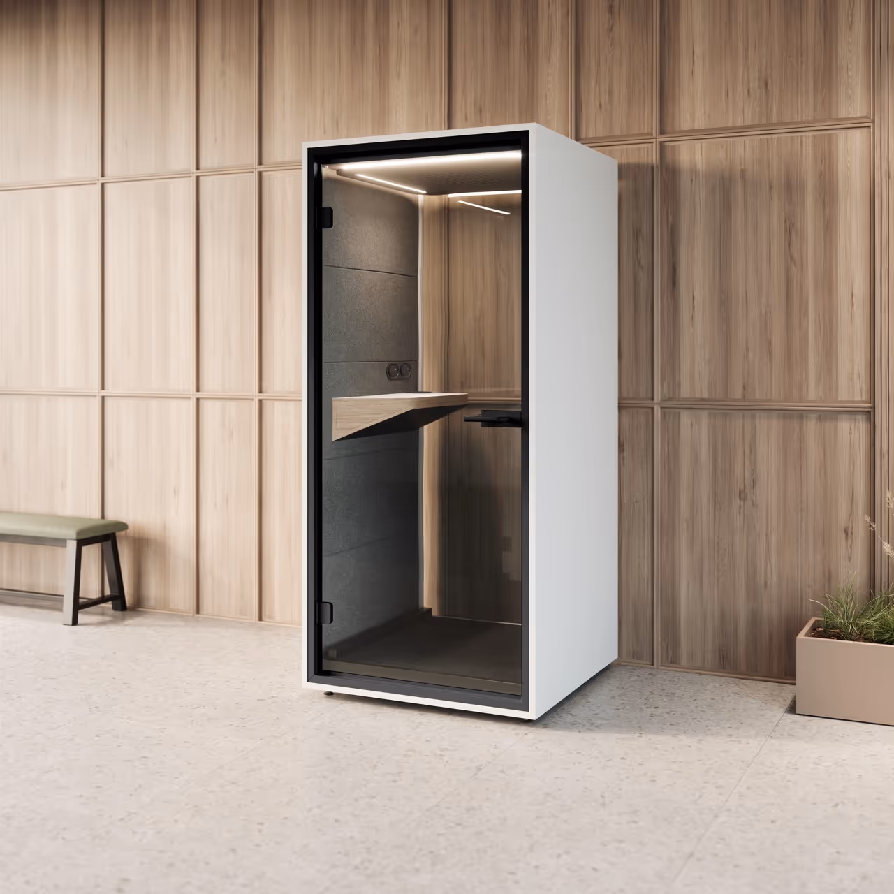 Moderne witte telefooncabine met glazen deur in een kamer met houten wandpanelen en betonnen vloer.