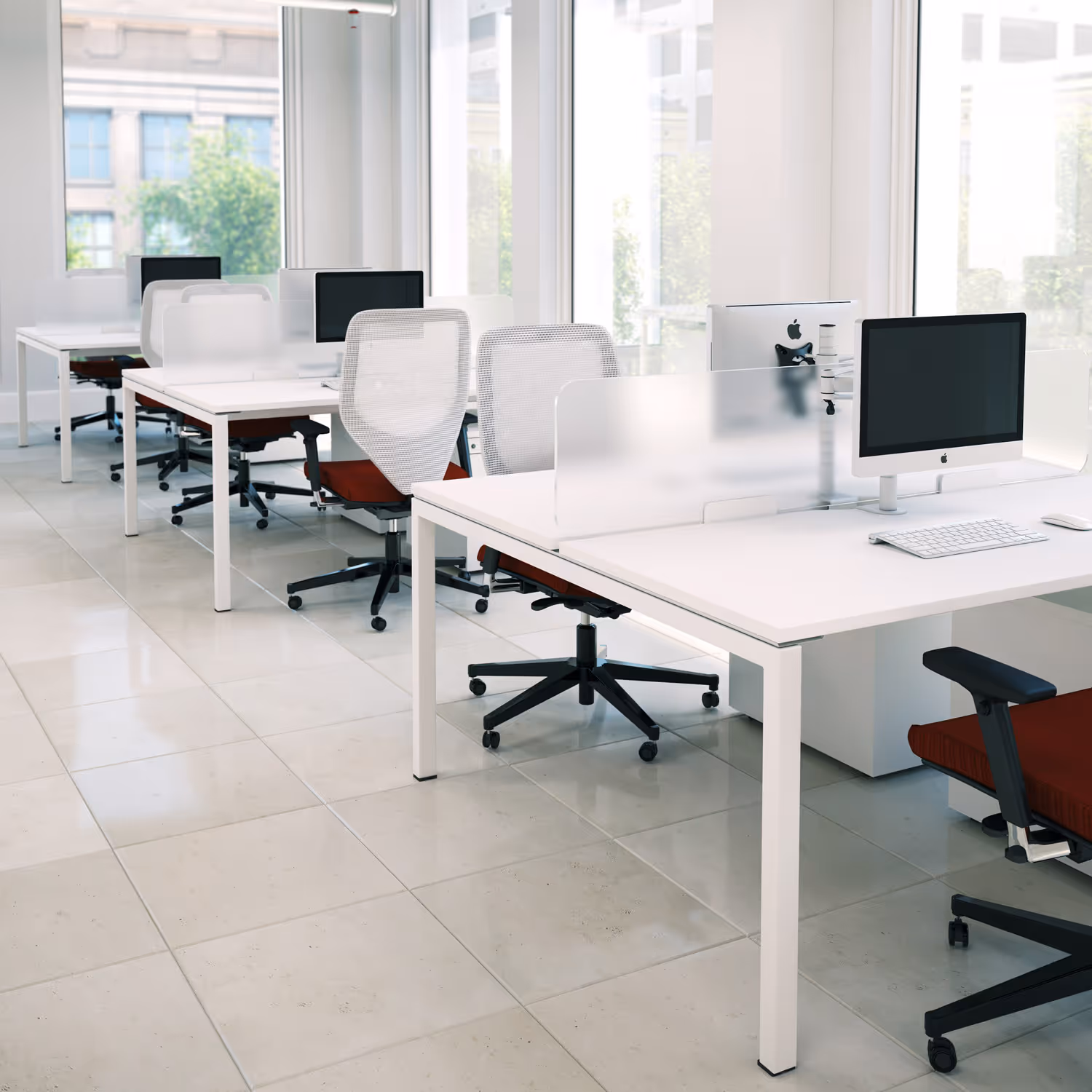 Moderne kantoorruimte met witte bureaus, rood gestoffeerde stoelen en desktopcomputers.