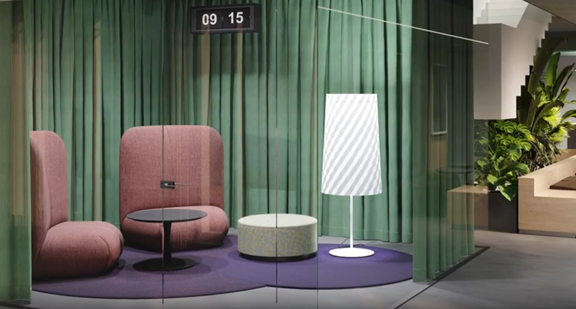 Moderne zithoek met paars kleed, roze stoelen, lage tafel en witte staande lamp achter glazen wand.