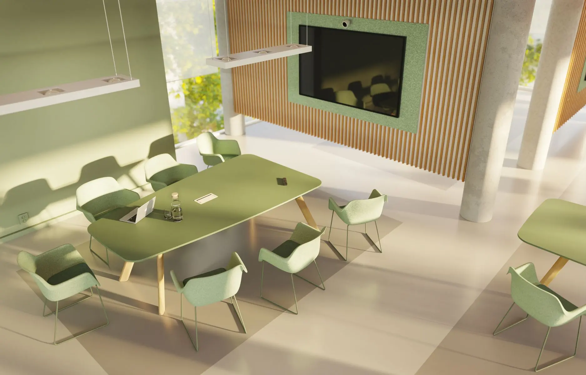 Moderne vergaderruimte met groene tafel en stoelen, grote tv aan houten wand, veel natuurlijk licht.