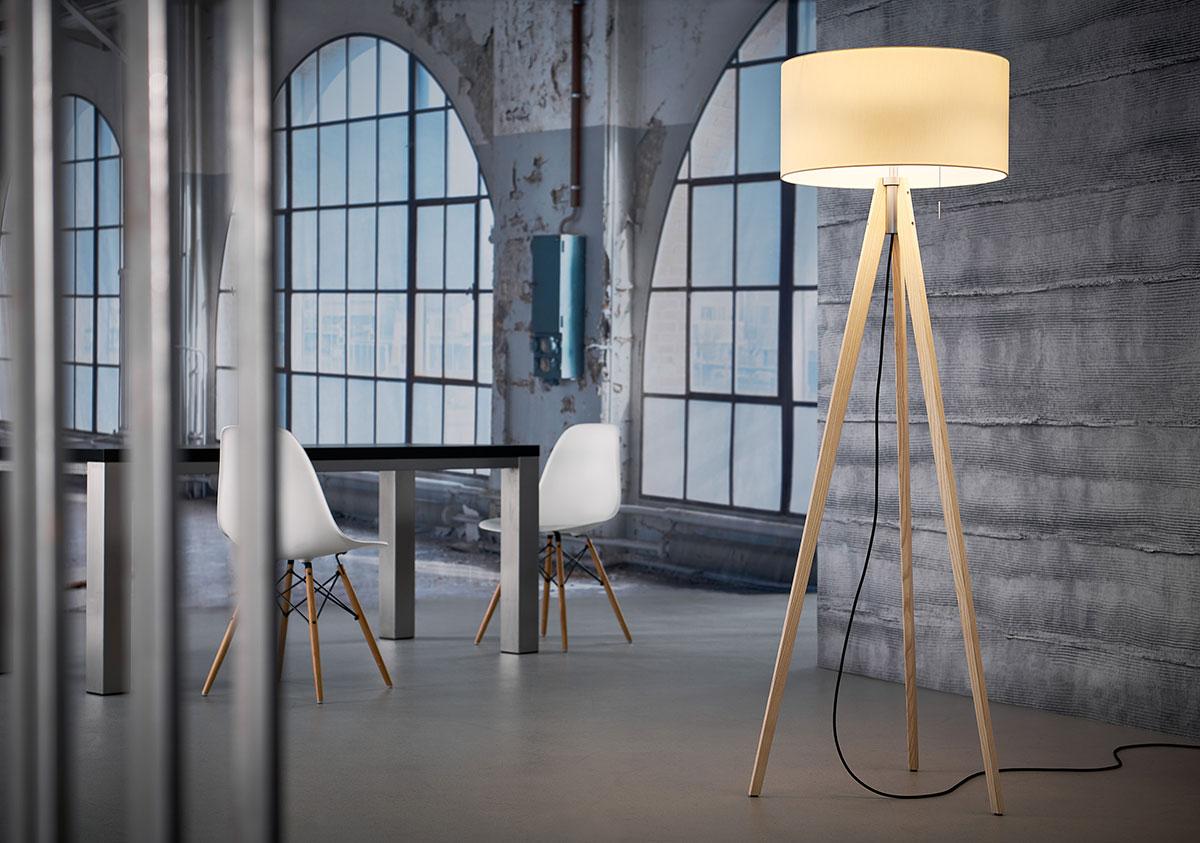 Moderne kamer met grote boogramen, een tafel met twee witte stoelen met houten poten, en een houten vloerlamp met een ronde beige lampenkap.