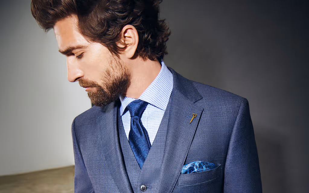 Man in suit sites on chair with red background