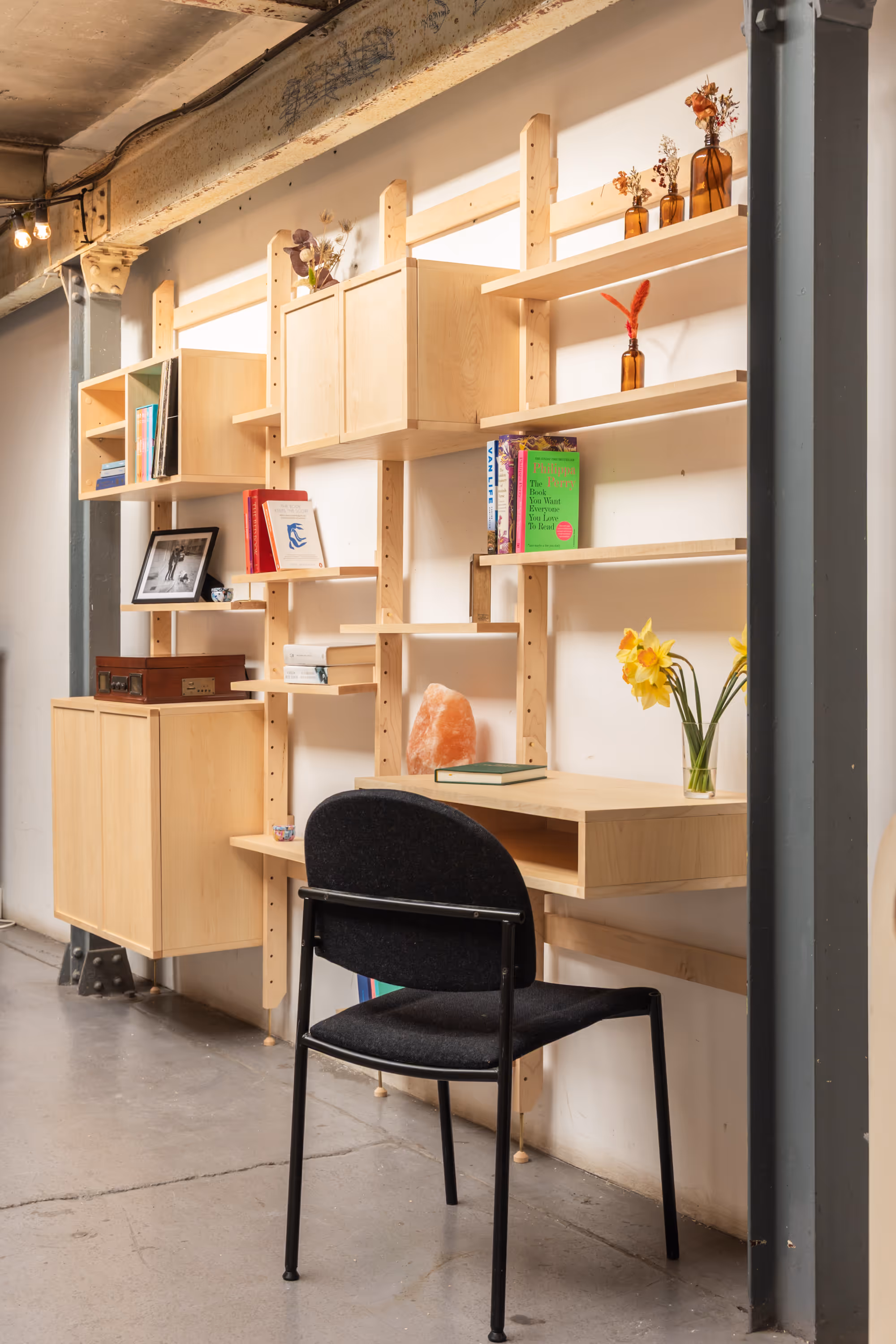 A wide, 4-bay Forma unit with a chair at a built-in desk, cabinets and shelves