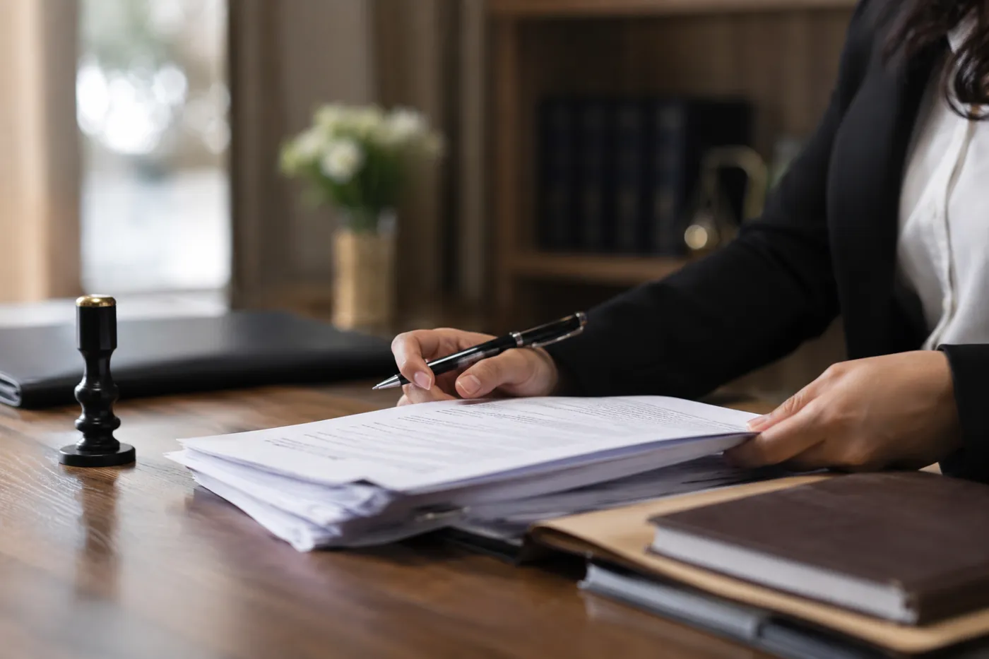 Mesa de escritório com documentos oficiais sendo analisados para tradução certificada de antecedentes criminais.