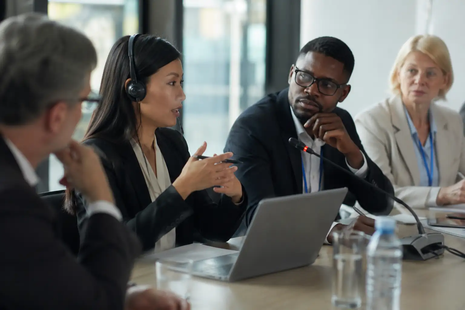 Profissionais participando de uma reunião empresarial internacional com serviço de interpretação simultânea em inglês, facilitando a comunicação entre empresas.