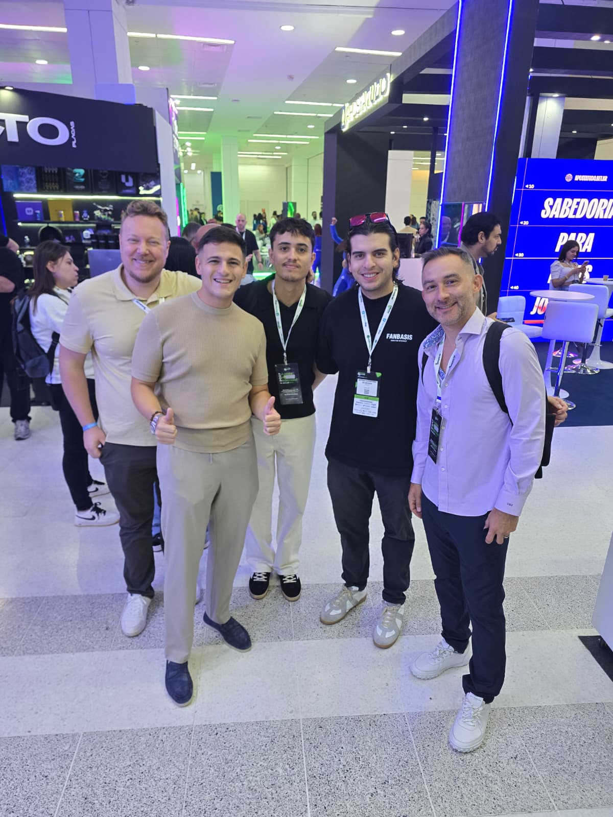 	Five men posing and giving thumbs up in the expo hall