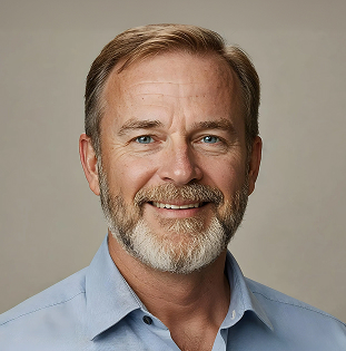 Smiling middle-aged man with short light brown hair, a beard, and blue eyes wearing a light blue shirt.