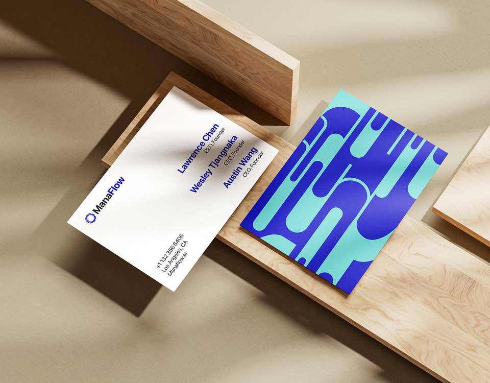 Two ManaFlow business cards on wooden blocks, one with blue abstract pattern, the other with contact info.