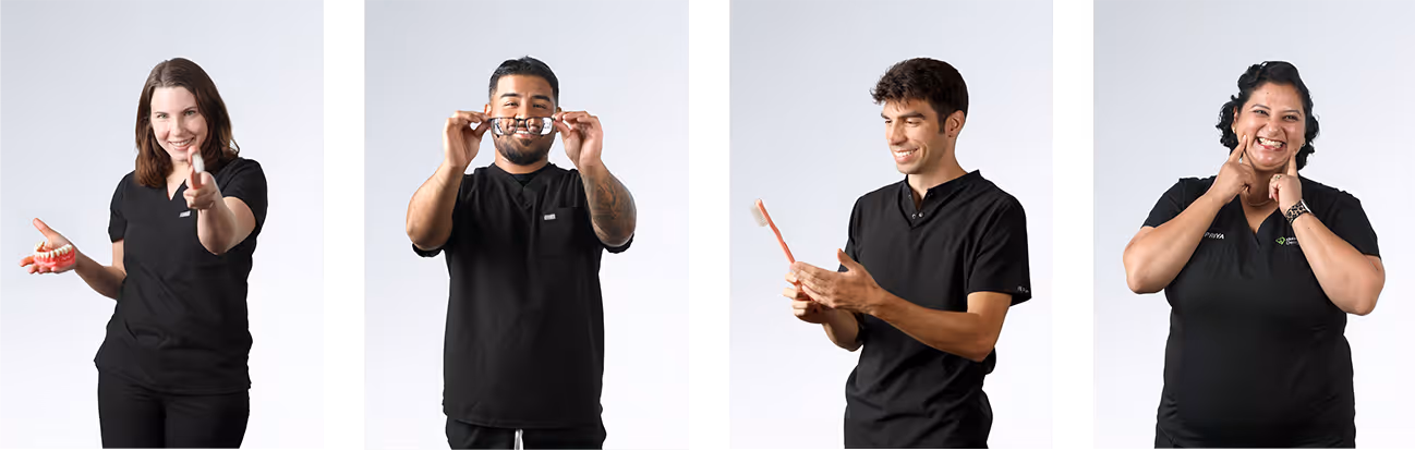Four dental professionals holding models, glasses, toothbrush, and smiling at the camera.